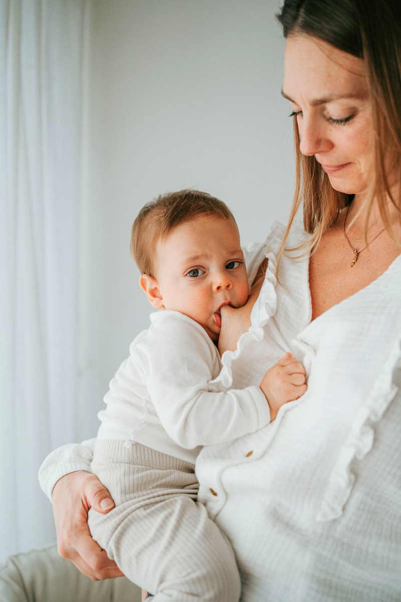 Bébé qui allaite sa maman grâce à l'ouverture invisible du chemisier dissimulé sous les volants de la chemises située aux épaules