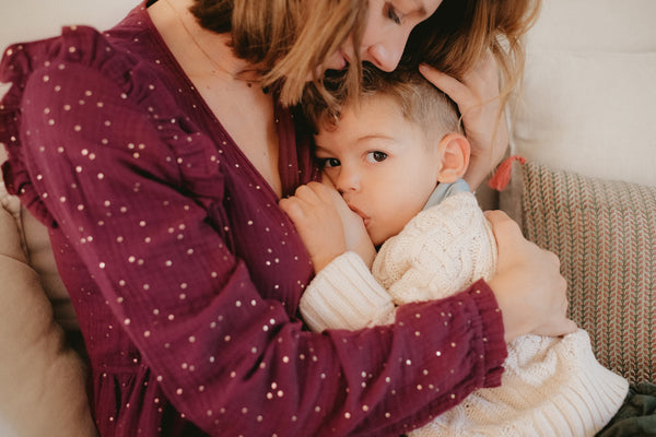 Un maman qui allaite son enfant grâce à sa robe d'allaitement pratique, qui s'ouvre sur le côté